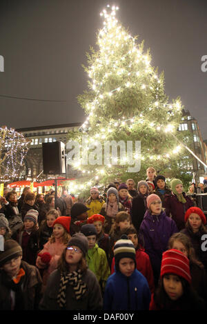 Les enfants de la chorale d'enfants et de jeunes St. Petri et St. Katharinen effectuer comme l'arbre de Noël est remis au marché de Noël le Rathausmarkt à Hambourg, Allemagne, 21 novembre 2011. Photo : Bodo Marks Banque D'Images