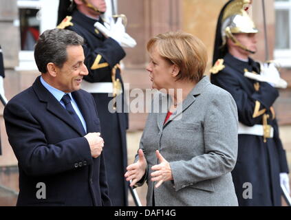 Le président français Nicolas Sarkozy (L) parle à la Chancelière allemande, Angela Merkel, à Strasbourg, France, 24 novembre 2011. Le président français Nicolas Sarkozy, la chancelière allemande Angela Merkel et le premier ministre Mario Monti rencontrez pour des entretiens sur la situation financière de la zone euro. Photo : ROLF HAID Banque D'Images