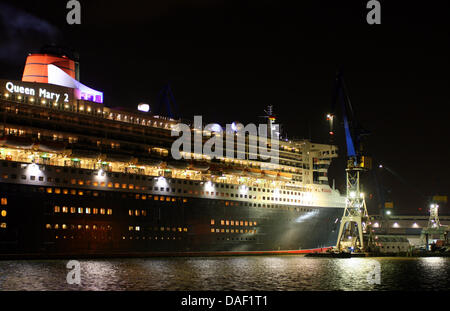 Le Queen Mary 2 docks à l'embarcadère de la cale sèche 'ELBE 17' au chantier naval Réparation Blohm  + Voss à Hambourg, Allemagne, le 26 novembre 2011. Au cours de l'escale de dix jours le bateau de croisière va recevoir des travaux d'entretien et de rénovation. Photo : Daniel Bockwoldt Banque D'Images