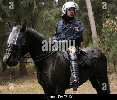 Un agent de police de la division de cavalerie porte un talisman que lui a donné sa fille avant la fin de l'opération près de Leitstade, Allemagne, 27 novembre 2011. Le 13ème transport de déchets nucléaires allemands est attendue en Wendland à partir de l'usine de retraitement en France cette semaine. Photo : JULIAN STRATENSCHULTE Banque D'Images