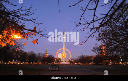 La grande roue est éclairée le soir au marché de Noël autour de la fontaine de Neptune en face de la tour de télévision et l'Hôtel de Ville à Berlin, Allemagne, 28 novembre 2011. Photo : JENS KALAENE Banque D'Images