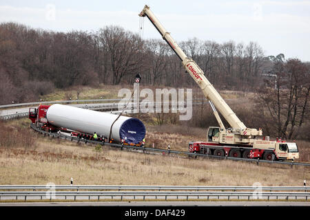 Un véhicule de transport lourd est récupéré par une grue sur la route d'accès à l'autoroute A1 en direction de Hambourg à la sortie Luebeck, Allemagne, 01 décembre 2011. Le chariot pour charge lourde est resté coincé à la sortie Aéroport de Lübeck en route vers Hambourg et bloque l'accès. Selon la police, le véhicule est éloigné de la route pour des raisons inconnues. La récupération ne doit Banque D'Images