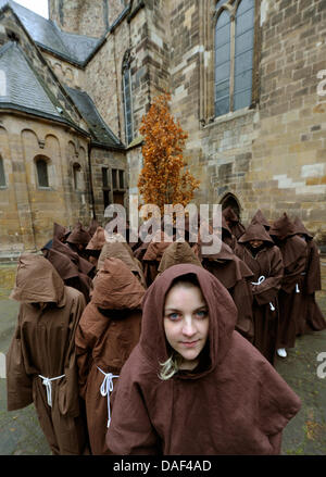 Christin Schneider comme "La Papesse Jeanne" et un certain nombre de moines posent devant le paramètre pour la comédie musicale "La Papesse Jeanne" (Die Paepstin) à la cathédrale de Saint-Boniface à Hamelin, Allemagne, 01 décembre 2011. À l'occasion du lancement du billet le 03 décembre 2011, Christin et les moines se balade dans le centre-ville de Hamelin. Celui qui reçoit ses premières taches des billets pour la premiere. L Banque D'Images