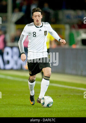 Joueur allemand Mesut Oezil contrôle le ballon pendant le match de football amical Allemagne contre l'Italie au stade Signal Iduna Park de Dortmund, Allemagne, 09 février 2011. Photo : Bernd Thissen Banque D'Images