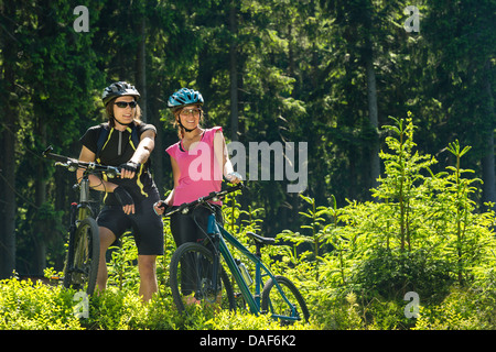 Les cyclistes de montagne comité permanent et de repos dans la nature ensoleillée de la forêt Banque D'Images