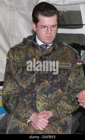 (Dossier) - Un fichier photo dpa en date du 10 mars 2010 indique le ministre allemand de la Défense Karl-Theodor zu Guttenberg portant un costume de camouflage avec son médecin à la poitrine cousue titre lors d'une visite aux troupes en Grafschaft-Gelsdorf, Allemagne. zu Guttenberg est confrontée à l'accusation de plagiat : les journaux de l'état qu'il a incorporé les articles par d'autres auteurs verbatim en sa thèse de doctorat. Photo : Banque D'Images