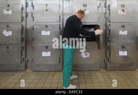 Le Dr Thomas médecin légiste Kramer ouvre l'un des compartiments de la morgue de l'établissement de médecine légale à Brême, Allemagne, 14 février 2011. Tous les morts, dont le décès a été suspect, sont conservés ici et sont autopsiés dans la section prix. Brême est le premier état à introduire une exigence de l'autopsie pour les enfants de moins de six ans. Photo : Ingo Wagner Banque D'Images