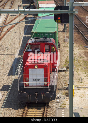 Locomotive rouge d'un long train de fret fret chargé avec des conteneurs photographié à Breda, Pays-Bas Banque D'Images