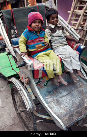 Les enfants indiens assis dans un pousse-pousse. Varanasi, Benares, Uttar Pradesh, Inde Banque D'Images