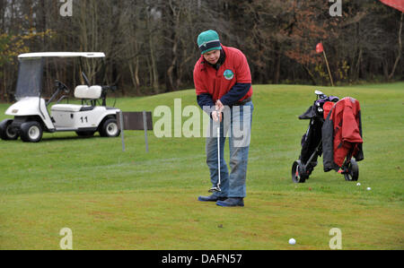 Christophe Schuler, joueur de golf avec la trisomie 21 putts, le bal à l'Lilienthal Golf Club à Lilienthal, Allemagne, 28 novembre 2011. Le club Lilienthal a été le premier à rompre avec la séparation des personnes handicapées ou non joueurs. Les joueurs de toutes les générations de la pièce sous la devise 'avec handicap à handicap'. Photo : Carmen Jaspersen Banque D'Images