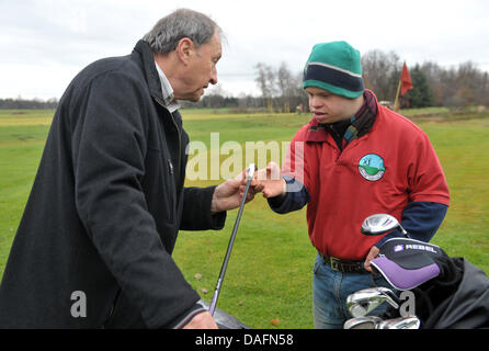 Christophe Schuler (R), joueur de golf avec la trisomie 21, et son père Dietrich, le vice-président du club, parlez à la Lilienthal Golf Club à Lilienthal, Allemagne, 28 novembre 2011. Le club Lilienthal a été le premier à rompre avec la séparation des personnes handicapées ou non joueurs. Les joueurs de toutes les générations de la pièce sous la devise 'avec handicap à handicap'. Photo : Carmen Jaspersen Banque D'Images