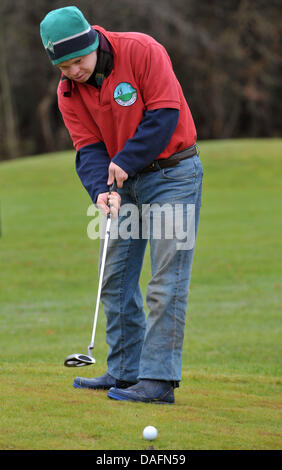 Christophe Schuler, joueur de golf avec la trisomie 21 putts, le bal à l'Lilienthal Golf Club à Lilienthal, Allemagne, 28 novembre 2011. Le club Lilienthal a été le premier à rompre avec la séparation des personnes handicapées ou non joueurs. Les joueurs de toutes les générations de la pièce sous la devise 'avec handicap à handicap'. Photo : Carmen Jaspersen Banque D'Images