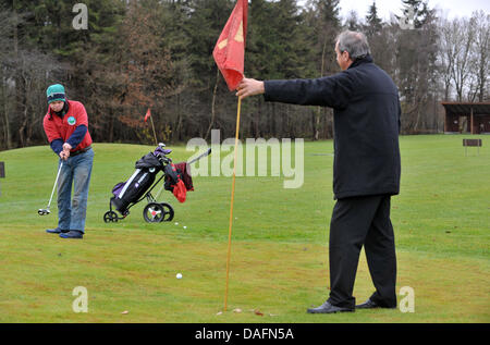 Christophe Schuler (L), joueur de golf avec la trisomie 21 putts, la balle vers son Père Dietrich, le vice-président du club, au Club de Golf de Lilienthal Lilienthal, Allemagne, 28 novembre 2011. Le club Lilienthal a été le premier à rompre avec la séparation des personnes handicapées ou non joueurs. Les joueurs de toutes les générations de la pièce sous la devise 'avec handicap à handicap'. Photo : Location Banque D'Images