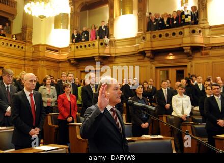 Le nouveau maire de Hambourg l'Olaf Scholz (SPD) (avant) lève la main au cours de la cérémonie d'inauguration à l'hôtel de ville de Hambourg, Allemagne, 7 mars 2011. Environ deux semaines après la victoire électorale des sociaux-démocrates de Hambourg (SPD), le citoyen de Hambourg ont voté Scholz comme leur nouveau maire. Photo : Angelika Warmuth Banque D'Images