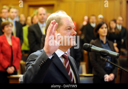 Le nouveau maire de Hambourg l'Olaf Scholz (SPD) (avant) lève la main au cours de la cérémonie d'inauguration à l'hôtel de ville de Hambourg, Allemagne, 7 mars 2011. Environ deux semaines après la victoire électorale des sociaux-démocrates de Hambourg (SPD), le citoyen de Hambourg ont voté Scholz comme leur nouveau maire. Photo : Angelika Warmuth Banque D'Images