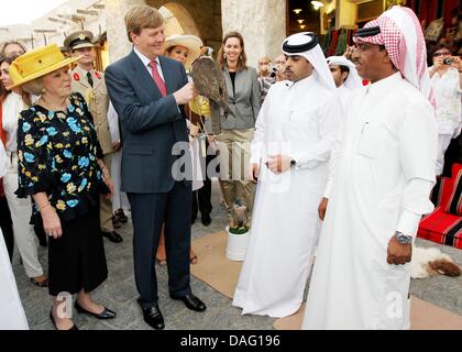 Le Prince Willem-Alexander des Pays-Bas est titulaire d'un faucon debout à côté de la Reine Beatrix (L) et de la princesse Maxima, portant un chapeau pendant leur visite du Souq Waqif bazar à Doha, Qatar, le 9 mars 2011. Les Royals néerlandais sont sur une visite d'Etat de deux jours au Qatar. Photo : Patrick van Katwijk Banque D'Images