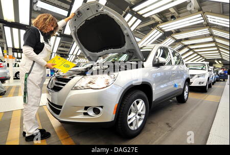 Un employé de le constructeur automobile allemand Volkswagen (VW) travaille sur un modèle de voiture VW Tiguan pendant l'inspection finale à la fin de la chaîne de montage de l'usine de production de l'entreprise de Wolfsburg, Allemagne, 24 février 2011. Photo : Jochen Luebke Banque D'Images