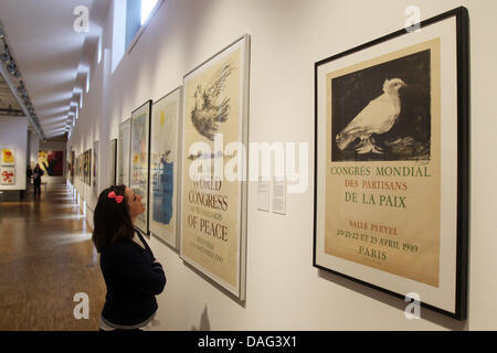 Les visiteurs d'un observe l'affiche 'congrès mondial des partisans de la paix' de Pablo Picasso à une conférence de presse de l'exposition 'Phantasy rencontre Alimentation - L'artiste politique des affiches au Musée fuer Kunst und Gewerbe à Hambourg, Allemagne, 16 mars 2011. L'exposition présente des actions de protestation avec plus de 180 œuvres de 90 artistes internationaux de ces 60 dernières années entre 18 mars un Banque D'Images