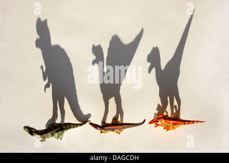 Trois prédateurs Dinosaures jouets d'affilée sur fond blanc avec des ombres Banque D'Images