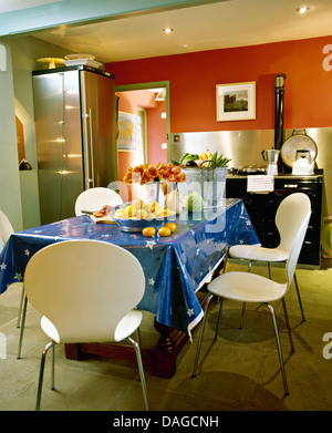 Tissu en PVC Bleu sur blanc table avec chaises Arne Jacobsen dans une cuisine moderne avec un réfrigérateur en acier noir et Aga Banque D'Images