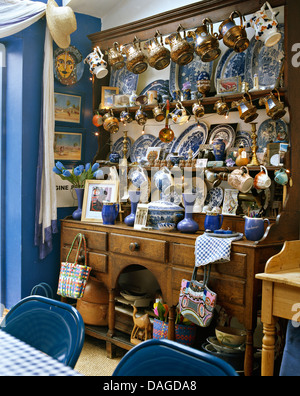 Pin commode encombrée avec grande collection de céramique pichets et bleu +plaques blanches dans la salle à manger chalet Banque D'Images