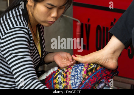 Vietnamienne faire pédicure dans les rues du vieux quartier de Hanoi, Vietnam Banque D'Images