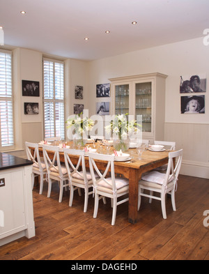 Chaises blanches à table simple en bois blanc moderne en cuisine salle à manger avec parquet et noir +blanc des photographies Banque D'Images