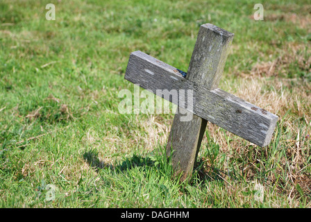 Petite croix en bois dans l'herbe d'un cimetière Banque D'Images