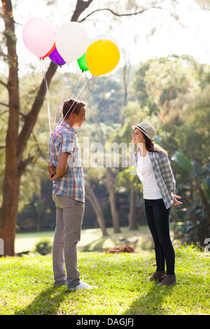 Garçon ado romantique avec des ballons d'hélium dating cute teen girl Banque D'Images