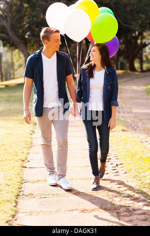 Adorable teenage couple en train de marcher dans le parc holding hands Banque D'Images