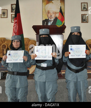 Trois officiers de police féminins avec le peuple afghan Police uniforme afficher leurs diplômes après avoir obtenu son diplôme de l'AUP academy à Sharan Hall le 26 juin 2013 dans la province de Paktika, Afghanistan. Banque D'Images