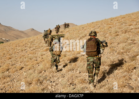 Les commandos de l'Armée nationale afghane avec la 1ère compagnie, 3e Kandak d'opérations spéciales monter une colline au cours d'une opération de nettoyage de combat le 3 juillet 2013 dans le district de Shah Wali Kot, dans la province de Kandahar, Afghanistan. Banque D'Images