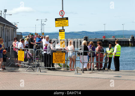 Largs Harbour, North Ayrshire, Écosse, Royaume-Uni, samedi 13 juillet 2013. Les gens qui font la queue pour le ferry de MacBrayne Caledonian pour voyager de la ville de Largs à l'île de Great Cumbrae dans le Firth de Clyde le premier samedi de la traditionnelle foire de Glasgow vacances. Banque D'Images