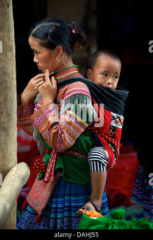 Mère Flower Hmong exerçant son enfant dans le dos, Coc Ly, près de l'ha, Vietnam Banque D'Images