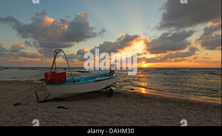 Fishingboat échoués au coucher du soleil sur la plage près d'Acre, Israël Banque D'Images