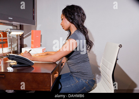 Young African American Woman working at a desk Banque D'Images