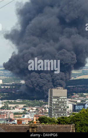 Sheffield, Royaume-Uni. 14 juillet, 2013. Un nuage de fumée épaisse est vu augmenter au Sheffield le Dimanche 14/07/2013. Yorkshire du Sud Services d'incendie et de Secours a signalé que l'incendie a pris naissance à partir d'une installation de déchets sur la rue Foley dans la zone de la ville Attercliffe et ont informé les résidents locaux pour maintenir les portes et fenêtres fermées. Crédit : Tom Stayte/Alamy Live News Banque D'Images