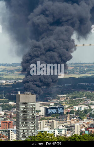 Sheffield, Royaume-Uni. 14 juillet, 2013. Un nuage de fumée épaisse est vu augmenter au Sheffield le Dimanche 14/07/2013. Yorkshire du Sud Services d'incendie et de Secours a signalé que l'incendie a pris naissance à partir d'une installation de déchets sur la rue Foley dans la zone de la ville Attercliffe et ont informé les résidents locaux pour maintenir les portes et fenêtres fermées. Crédit : Tom Stayte/Alamy Live News Banque D'Images