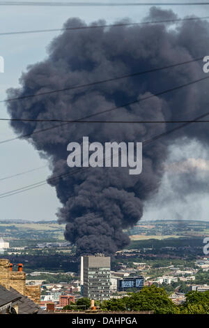 Sheffield, Royaume-Uni. 14 juillet, 2013. Un nuage de fumée épaisse est vu augmenter au Sheffield le Dimanche 14/07/2013. Yorkshire du Sud Services d'incendie et de Secours a signalé que l'incendie a pris naissance à partir d'une installation de déchets sur la rue Foley dans la zone de la ville Attercliffe et ont informé les résidents locaux pour maintenir les portes et fenêtres fermées. Crédit : Tom Stayte/Alamy Live News Banque D'Images