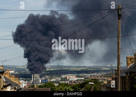 Sheffield, Royaume-Uni. 14 juillet, 2013. Un nuage de fumée épaisse est vu augmenter au Sheffield le Dimanche 14/07/2013. Yorkshire du Sud Services d'incendie et de Secours a signalé que l'incendie a pris naissance à partir d'une installation de déchets sur la rue Foley dans la zone de la ville Attercliffe et ont informé les résidents locaux pour maintenir les portes et fenêtres fermées. Crédit : Tom Stayte/Alamy Live News Banque D'Images