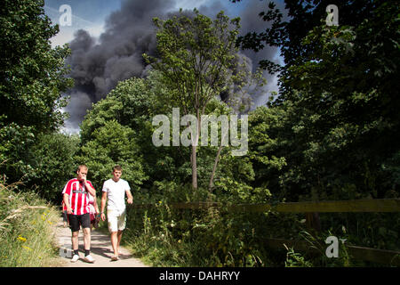 Sheffield, Royaume-Uni. 14 juillet, 2013. Les gens qui marchent le long de la 5 marche wiers comme une épaisse fumée noire s'élève hors de l'incendie d'un centre de recyclage sur Foley Street à Sheffield Crédit : Gary Bagshawe/Alamy Live News Banque D'Images