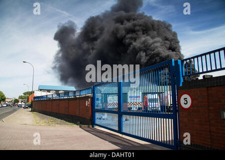 Sheffield, Royaume-Uni. 14 juillet, 2013. Une épaisse fumée noire s'échapper hors de Recycling center fire sur Foley Street à Sheffield Crédit : Gary Bagshawe/Alamy Live News Banque D'Images