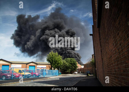 Sheffield, Royaume-Uni. 14 juillet, 2013. Une épaisse fumée noire s'échapper hors de Recycling center fire sur Foley Street à Sheffield Crédit : Gary Bagshawe/Alamy Live News Banque D'Images