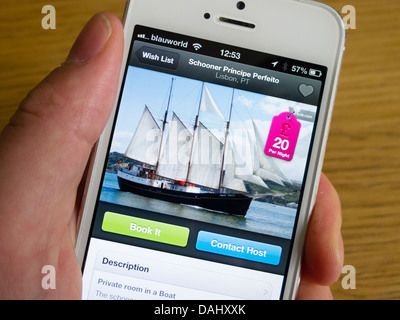 En utilisant Airbnb app de réserver hébergement de vacances sur un voilier avec un smartphone iPhone 5 Banque D'Images