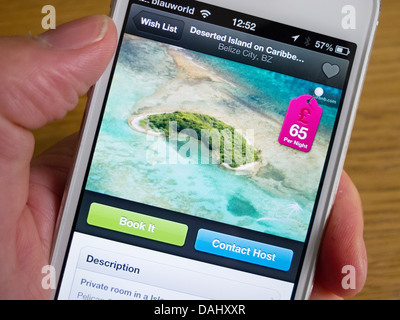 En utilisant Airbnb app de réserver hébergement de vacances sur une île privée avec un smartphone iPhone 5 Banque D'Images