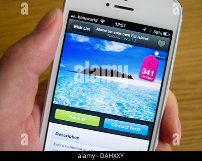 En utilisant Airbnb app de réserver hébergement de vacances sur une île privée avec un smartphone iPhone 5 Banque D'Images