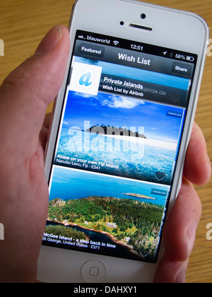 En utilisant Airbnb app de réserver hébergement de vacances sur une île privée avec un smartphone iPhone 5 Banque D'Images