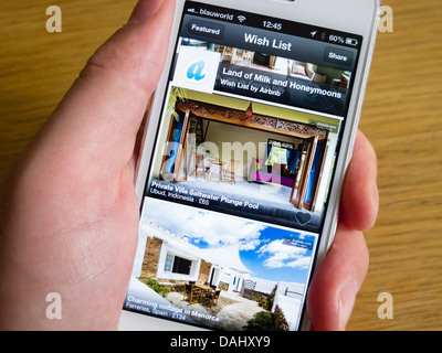 En utilisant Airbnb app de réserver hébergement de vacances sur un smartphone iPhone 5 Banque D'Images