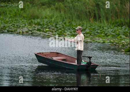 Une fine homme debout et la pêche d'un petit bateau à rames sur la rivière Haines Creek dans le comté de Lake, Leesburg Florida USA Banque D'Images