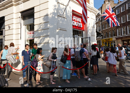 Cinq gars en dehors de files d'burger restaurant récemment ouvert en Covent garden London, England uk Banque D'Images